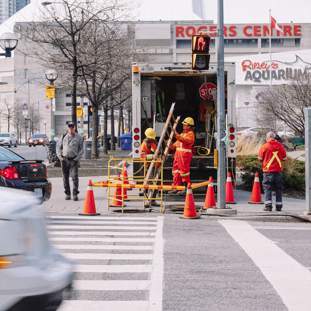 Traffic Management Implementer Skill Set team managing roadworks with cones, stop signs, and safety equipment in an urban setting