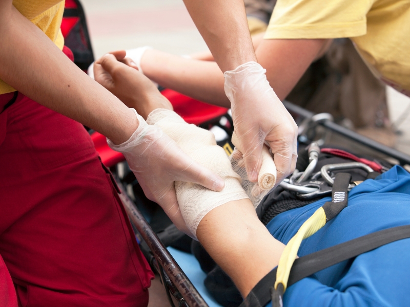 Emergency responders bandaging a wound during a drill focused on implementing an effective first aid plan for injuries.