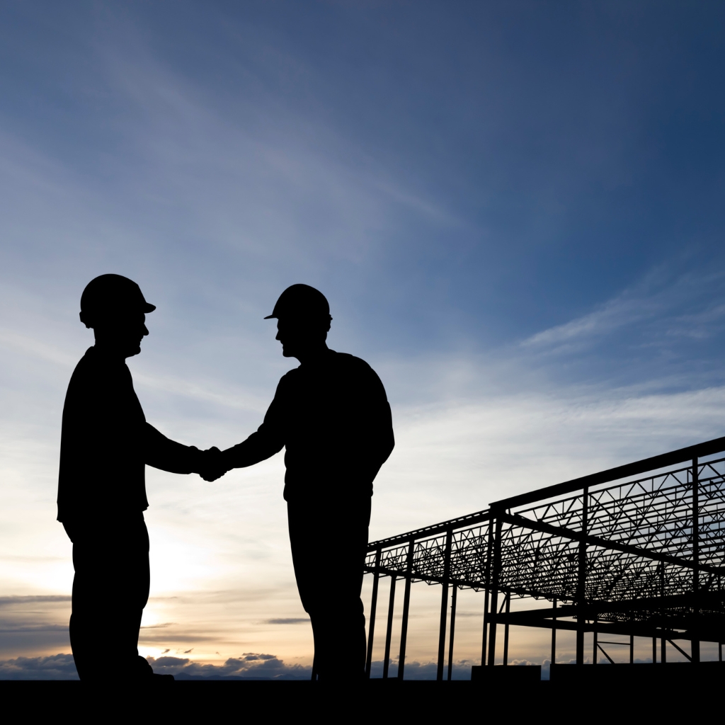 Traffic Controller Skill Set teamwork handshake during sunset at a construction site emphasising collaboration and safety.