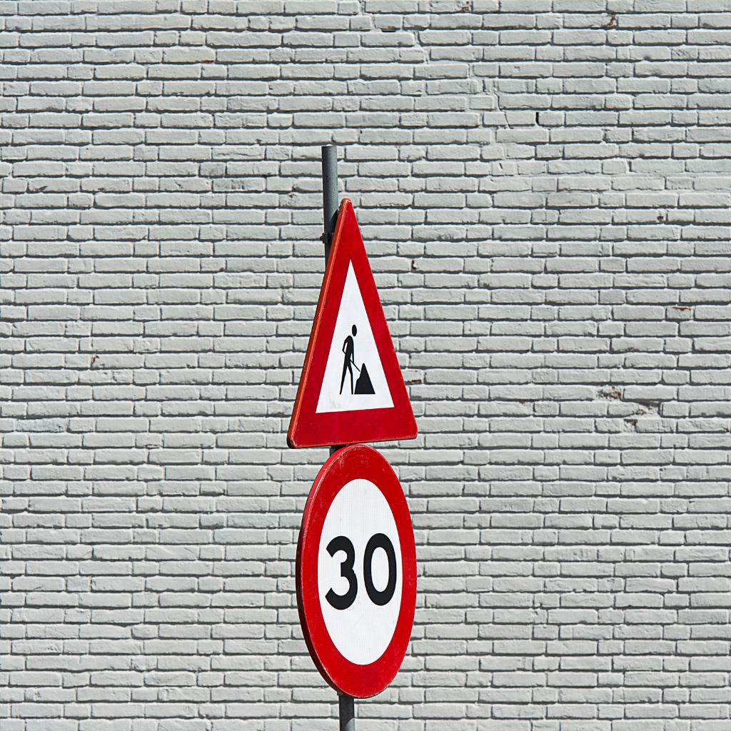 Traffic Management Designer Skill Set showing road construction warning sign with speed limit 30 against a white brick background