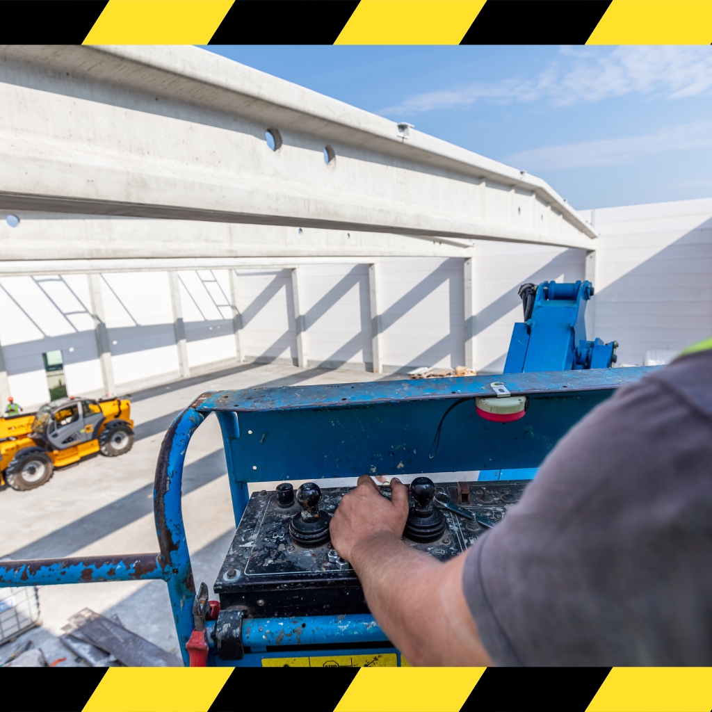 Operator controlling an EWP (Over 11 meters) for elevated construction work inside a modern warehouse building.