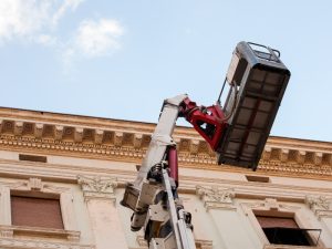 Elevated work platform positioned near a building, highlighting the importance of site risk assessment during operations.