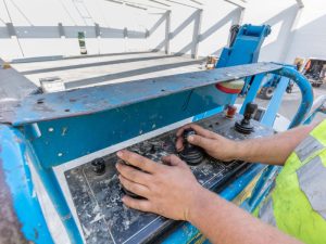 Close-up of hands operating an elevated work platform.